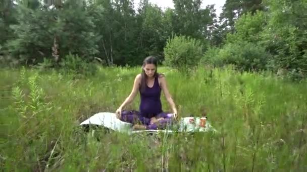 Joven embarazada haciendo yoga fuera . — Vídeo de stock