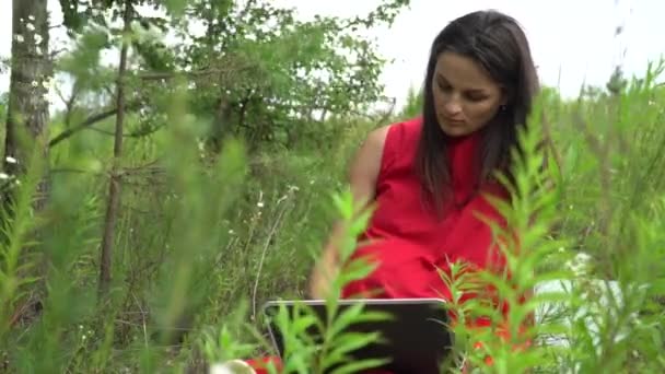 Joven mujer de moda tecleo teclado. Chica usando el ordenador portátil fuera . — Vídeo de stock