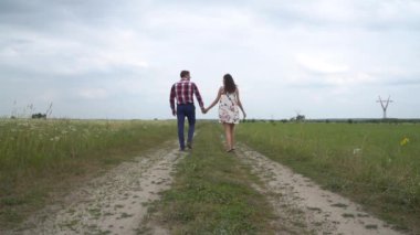 Hamile çift yürüyen bir arada tutan eller. Erkek ve kadın elele.