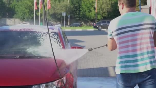 Νεαρός άνδρας Καυκάσιος πλύσιμο του αυτοκινήτου για το πλύσιμο αυτοκινήτων σελφ-σέρβις. Πλυντήριο αυτοκινήτων. — Αρχείο Βίντεο