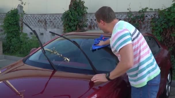 Un joven caucásico lavando su coche en el auto-servicio de lavado. Lavado de coches . — Vídeos de Stock