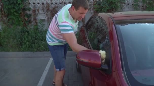 Un joven caucásico lavando su coche en el auto-servicio de lavado. Lavado de coches . — Vídeos de Stock