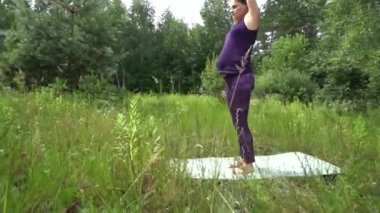 Genç hamile kadın dışında yoga yaparken.