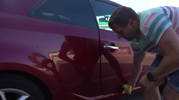 Young caucasian man washing his car on the car wash self-service. Car washing. — Stock Video