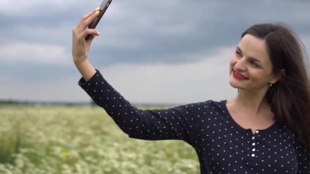 Bella ragazza facendo selfie, foto con fiori di camomilla all'esterno . — Video Stock