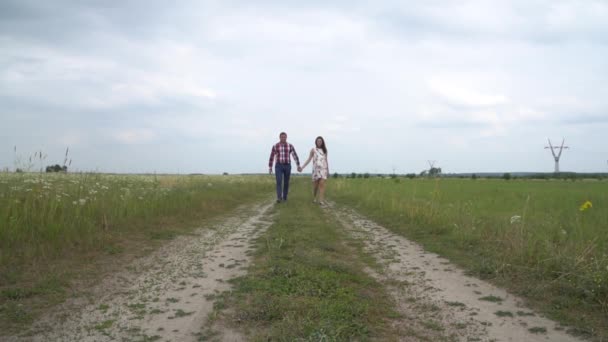 Zwangere paar wandelen samen houden handen. Man en vrouw hand in hand. — Stockvideo