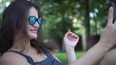 Şezlong üzerinde rahatlatıcı ve selfies Smartphone cep telefonu ile yapıyor güzel kadın.