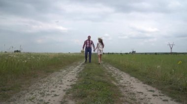 Hamile çift yürüyen bir arada tutan eller. Erkek ve kadın elele.