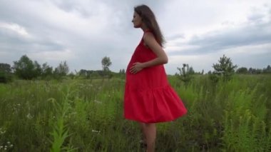 Hamile genç kadın alanda yürüyüş.