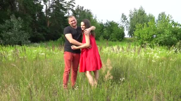 Krásný pár muž a těhotná žena s dlouhými vlasy v červených šatech. rodina. — Stock video