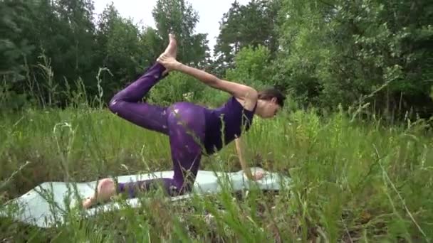 Giovane donna incinta che fa yoga fuori . — Video Stock