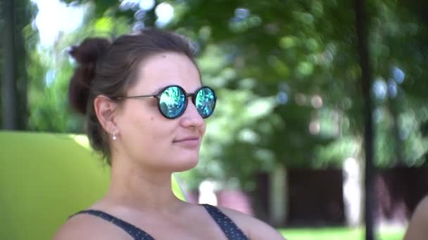 Mujer joven en gafas de sol relajante en el sol de verano . — Vídeos de Stock