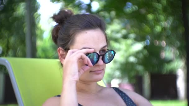 Mujer Joven Gafas Sol Relajándose Bajo Sol Verano Mientras Reclina — Vídeos de Stock
