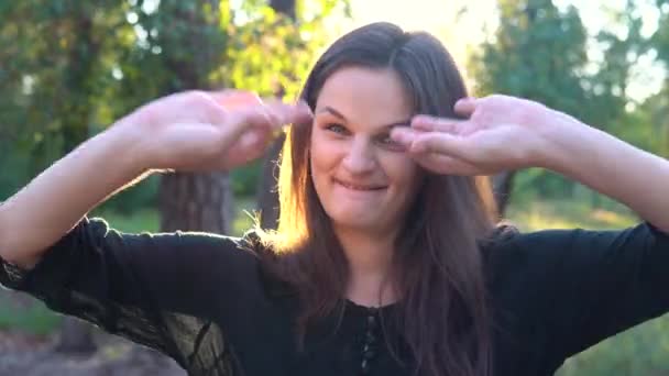 Funny yong woman shows eyglasses with her fingers. Body gesture. — Stock Video