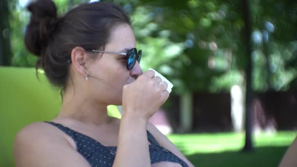Şezlong üzerinde yalan sırasında kahve içme kadın. — Stok video