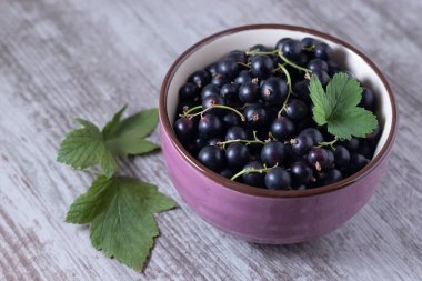 Ahşap bir masada siyah frenk üzümü.