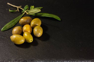 Kopya alanı için siyah arkaplanda yaprakları olan zeytin ve zeytin dalı.
