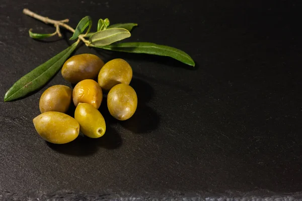 Kopya alanı için siyah arkaplanda yaprakları olan zeytin ve zeytin dalı.