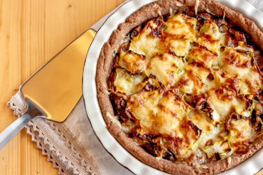 Mantarlı tart. Hafif ahşap arka planda mantarlı kiş turtasının üst görüntüsü