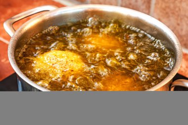 Sicilya sokak yemekleri Arancini tavada kaynar zeytinyağında kızarıyor. İtalyan fast food. Seçici odak.