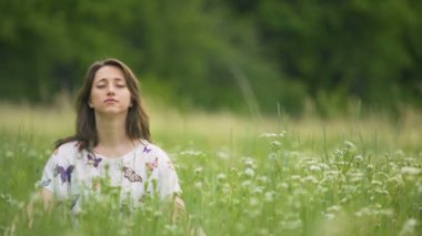 Genç kadın yüksek yeşil çimen, doğa ile birliğini meditasyon düşünmeyi bırak