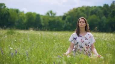 Kadın açık havada poz lotus meditasyon içinde oturur, Rüzgar saç, birliğini doğa taşır