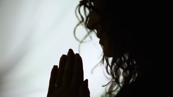 ために神を求めて シルエットを祈って祈りの手を保持している女性をクローズ アップ — ストック動画
