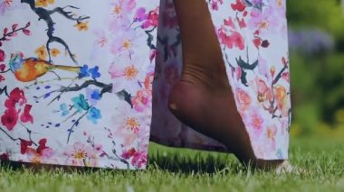 Kadın ayak ayak parmakları renkli elbiseli yeşil çimenlerin üzerinde yürüyüş, bahar açık geldi