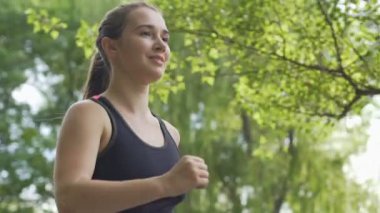 Gülümseyen kadın çalışan güneş ışınları, temiz havada güzel spor koşu sabah
