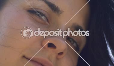 Koyu saçlı kadın görünüyor kamera flört gözler, parlak ışık, bellek geriye dönüş