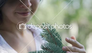 Gülümseyen kadın yavaşça okşar Çamın dalları, Doğa, çevre bakım sevgisi