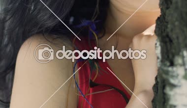 Utangaç kadın ayakta yakınındaki tarihi ortağı için ağaç koyu saçlı güzellik beklemek aşağı görünüyor