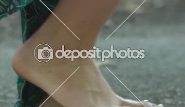 Kadın kesiminden yalınayak beton şehir yüksek topuk ayakkabı el closeup taşır.