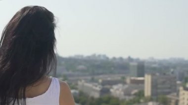 Şehir arazi scape üzerinde güzel çekici Bayan dönüyor, kadın kamera görünüyor