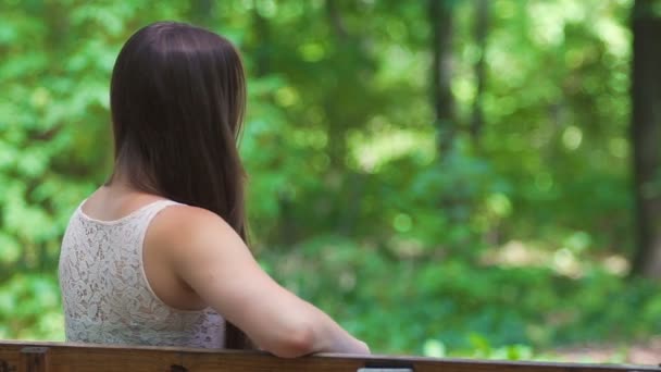 Young Brunette Turns Sitting Bench Smiling Woman Feels Happy Outdoors — Stock Video