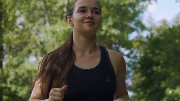 慢动作的女跑步者 微笑的女人在公园里慢跑 — 图库视频影像