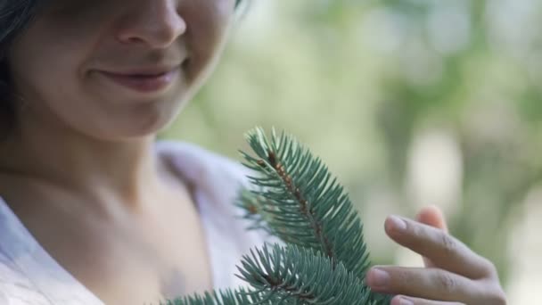 微笑的女人温柔地爱抚松枝 热爱自然 — 图库视频影像