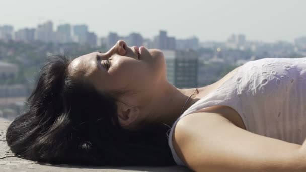 Woman Lying Edge Rooftop Turns Head Smiling Beautiful Relaxed Female — Stock Video