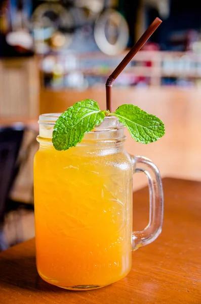 ahşap masa üzerine nane yaprakları ile cam şişe buzlu çay