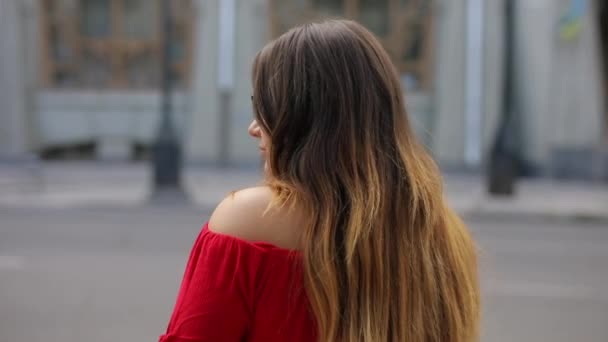 Ragazza con i capelli lunghi in occhiali gira la testa verso la fotocamera — Video Stock