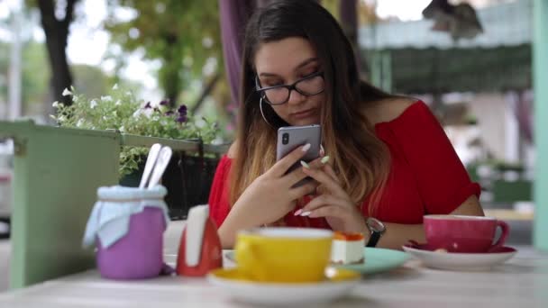 Donna scatta foto di dessert in un caffè ed esamina le foto — Video Stock