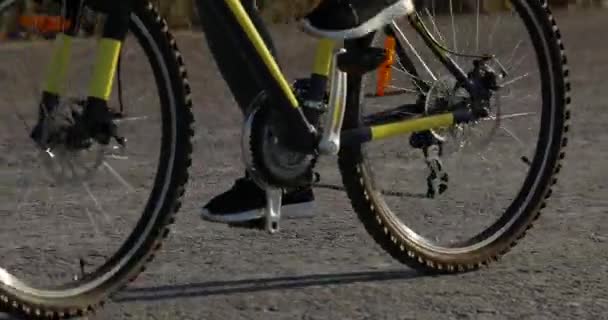 Personne méconnaissable monte un vélo jaune, pédales — Video