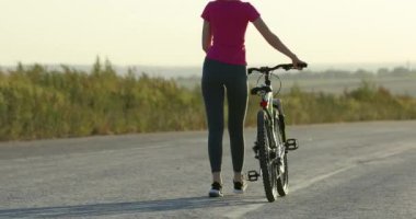 Bisikletçi sarı gözlüklü bisikletle yolda yürüyor.