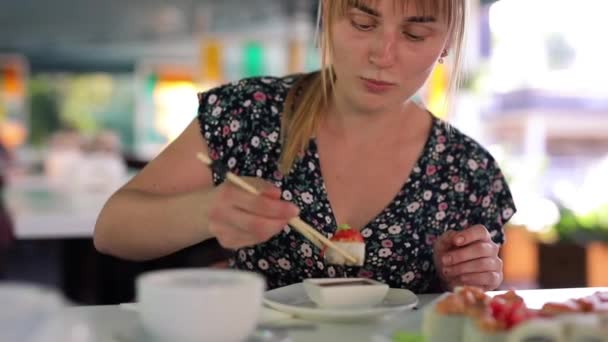Gelukkige vrouw eet sushi broodjes — Stockvideo