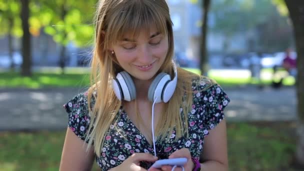 Mujer sorprendida hablando por teléfono con auriculares — Vídeos de Stock