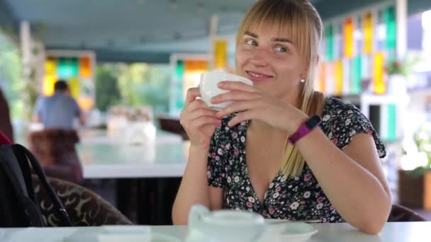 Gelukkig vrouw drinken thee in een cafe en ontspannen — Stockvideo
