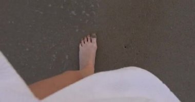 Kadın bacakları kıyı boyunca yürür, üst manzara