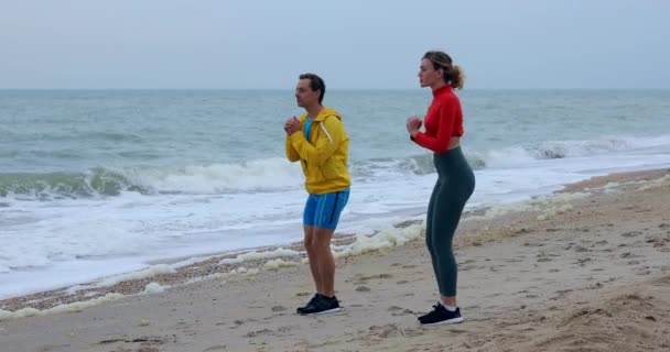 Casal feliz fazendo treinamento esportivo pelo mar — Vídeo de Stock