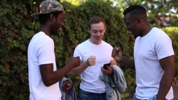 Tre multiracial vänner spelar ett spel och skrattar — Stockvideo