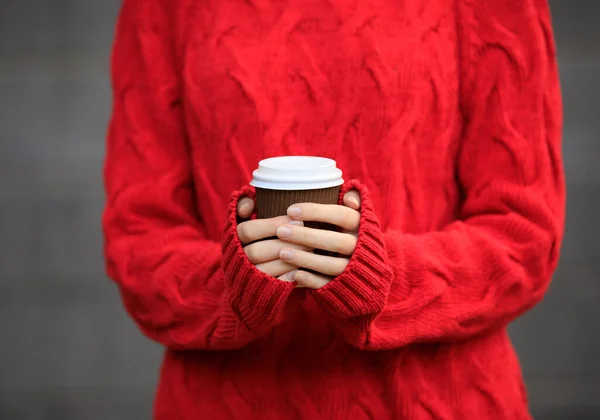 Kırmızı kazaklı tanınmayan kişi elinde bir fincan sıcak içecek tutuyor. — Stok fotoğraf